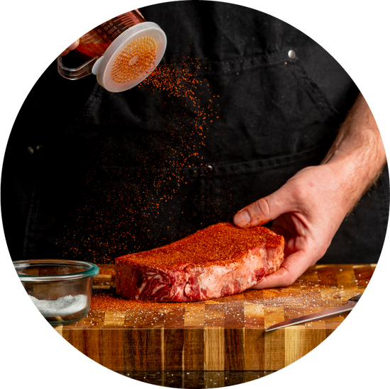 man sprinkling rub onto steak